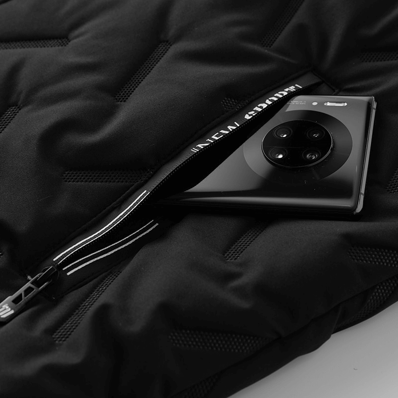 Sleek black smartphone partially unzipped from a quilted black jacket on a soft surface.